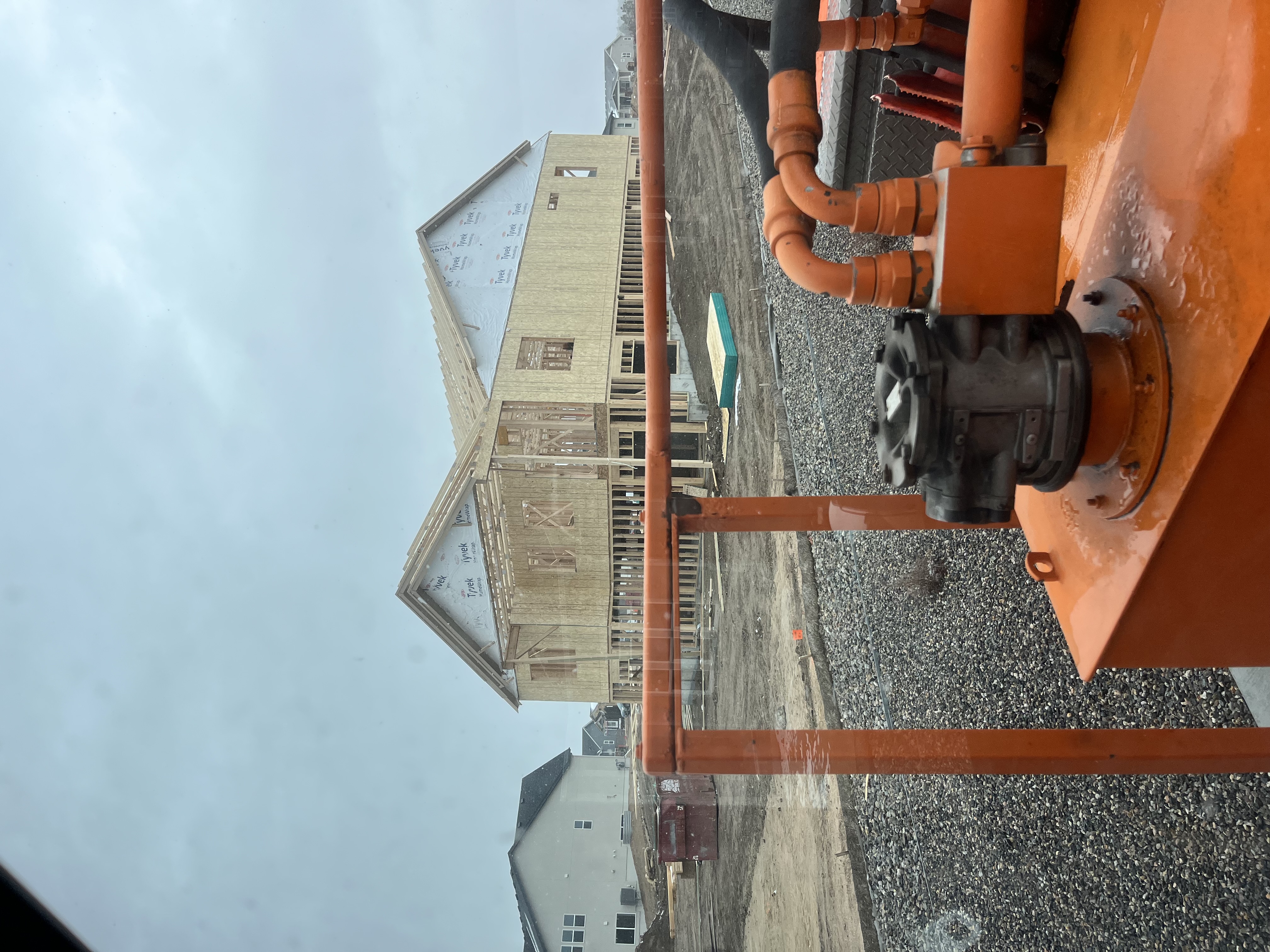 Crane truck at Front Range residential construction site with mountain views